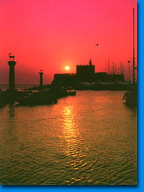 The two deers and the lighthouse of Rhodes harbor at sunrise.